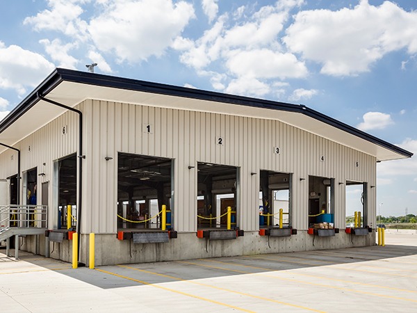Pre-engineered metal warehouse with multiple loading dock doors and truck bays.